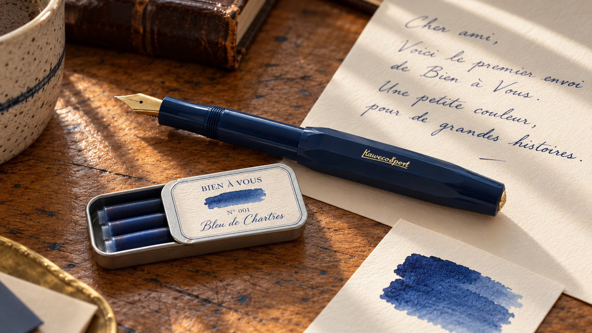 A handwritten letter beside tin Nº 001 Bleu de Chartres and a navy fountain pen